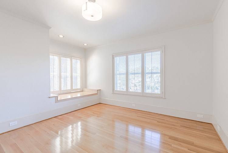 an empty living room with white walls and wood floors and a window