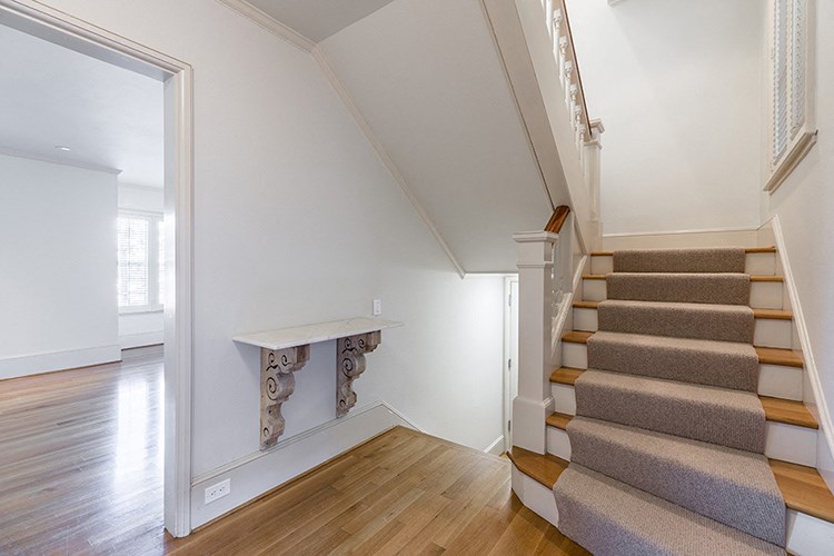 a view of a staircase in a home with white walls and wood floors