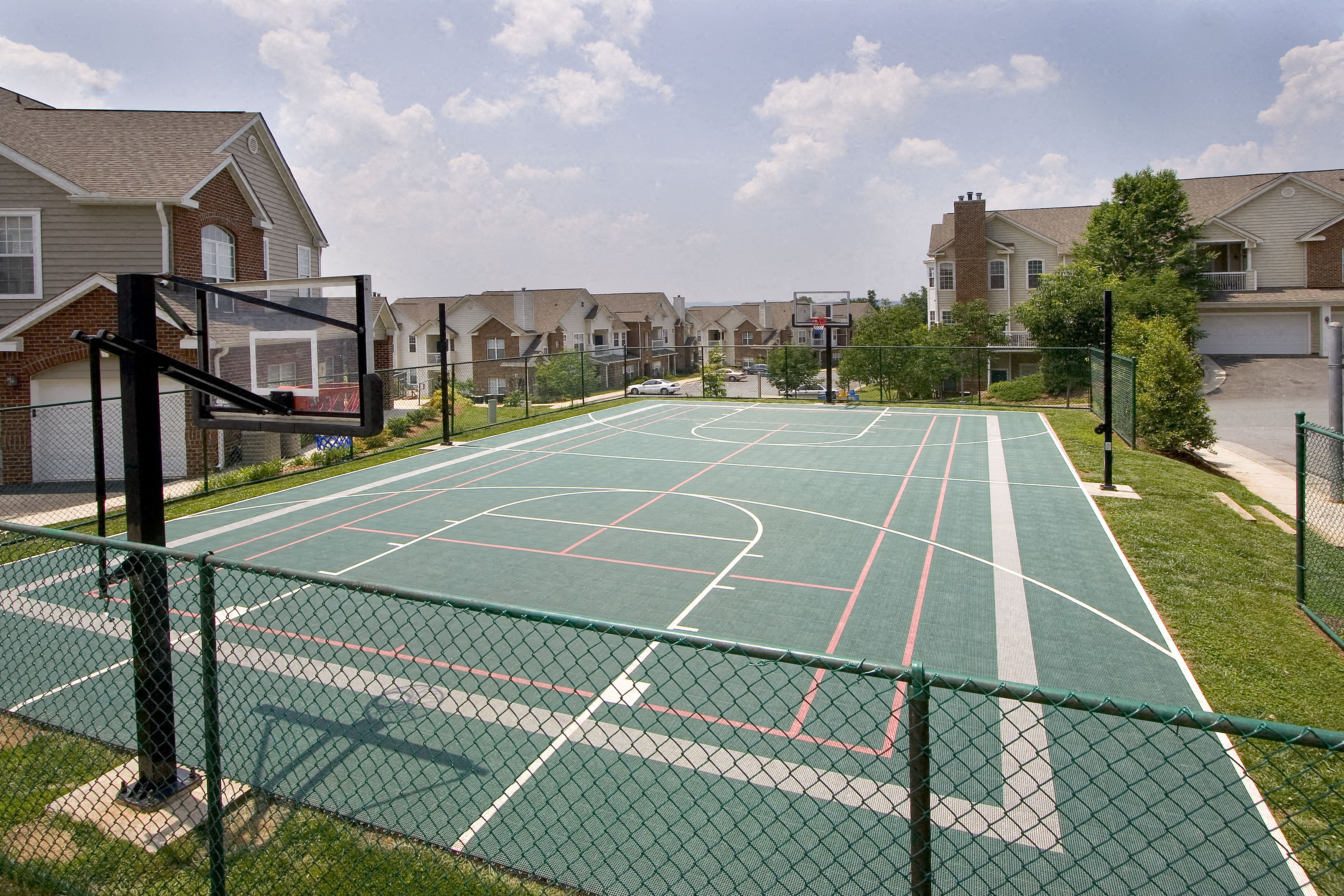 a tennis court with apartments in the background