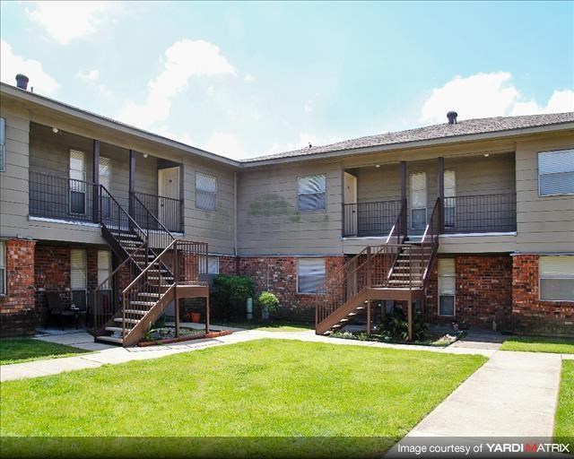 an apartment building with stairs and a lawn