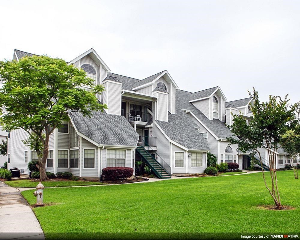a row of houses on a green lawn and a fire hydrant