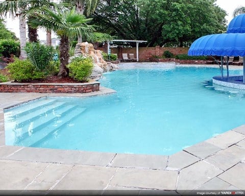a swimming pool with a blue umbrella next to it