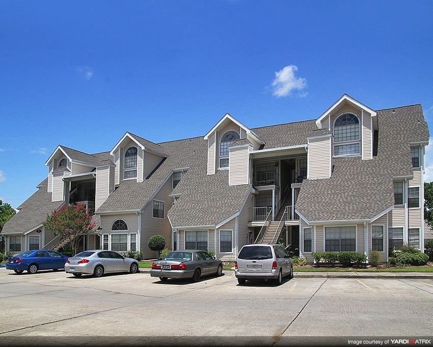 a large apartment building with cars parked in front of it