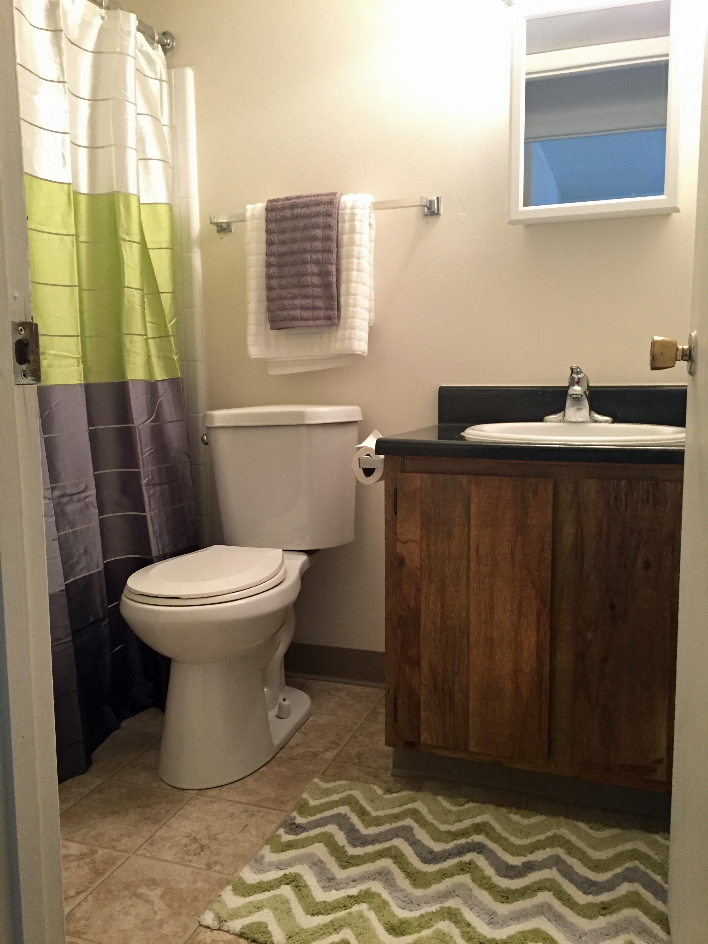 a bathroom with a toilet and a sink and a shower curtain