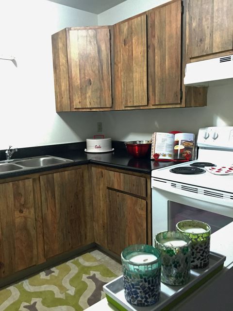 a small kitchen with wooden cabinets and a stove and a sink