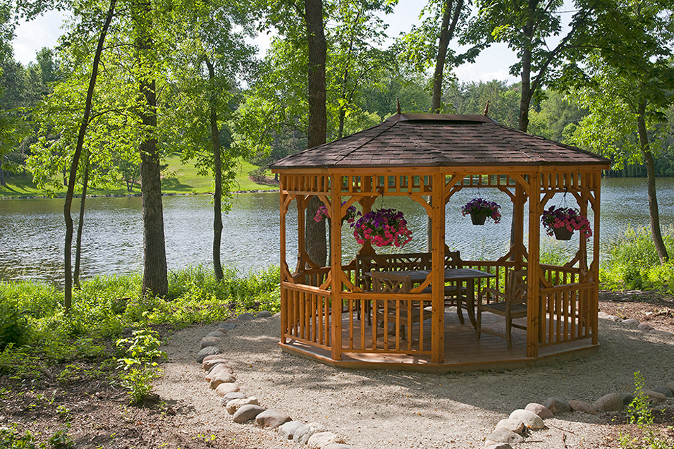 wooden gazebo surrounded by trees overlooking a lake