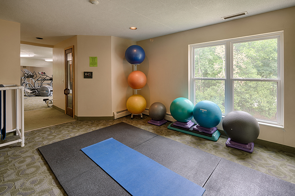 fitness room with exercise balls and yoga mat