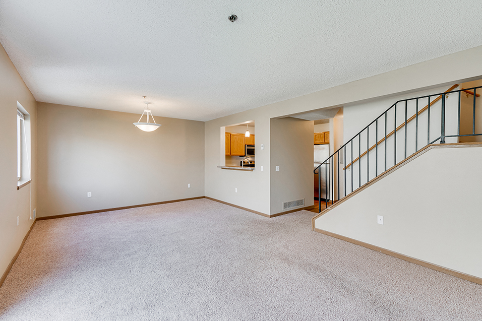 lit living room with view of the stairs and kitchen