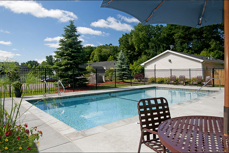 outdoor pool with deck chair and table with umbrella