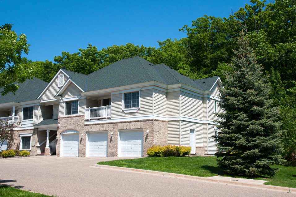 Townhome surrounded by lush green trees and grass