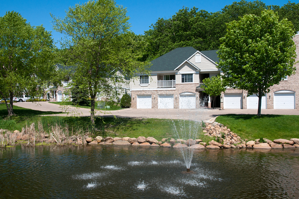 Townhome overlooking a lake with a fountain in it