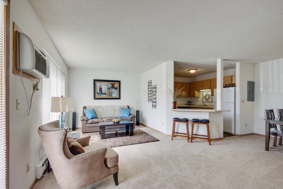 a living room with a couch and a chair and a kitchen
