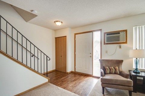 a living room with a chair and a door to a staircase