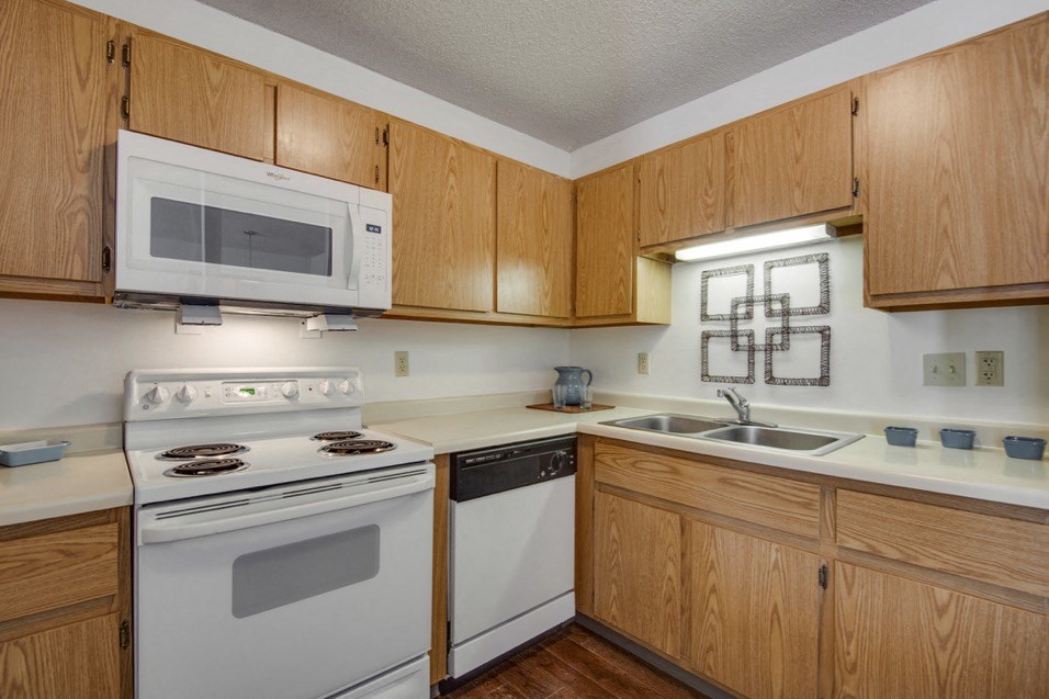 a kitchen with white appliances and wooden cabinets