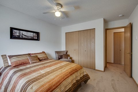 a bedroom with a bed and a ceiling fan