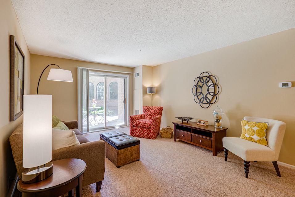 a living room with a couch and chairs and a window
