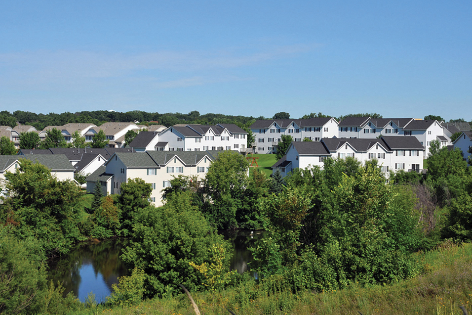 overlooking shot of multiple townhomes and trees