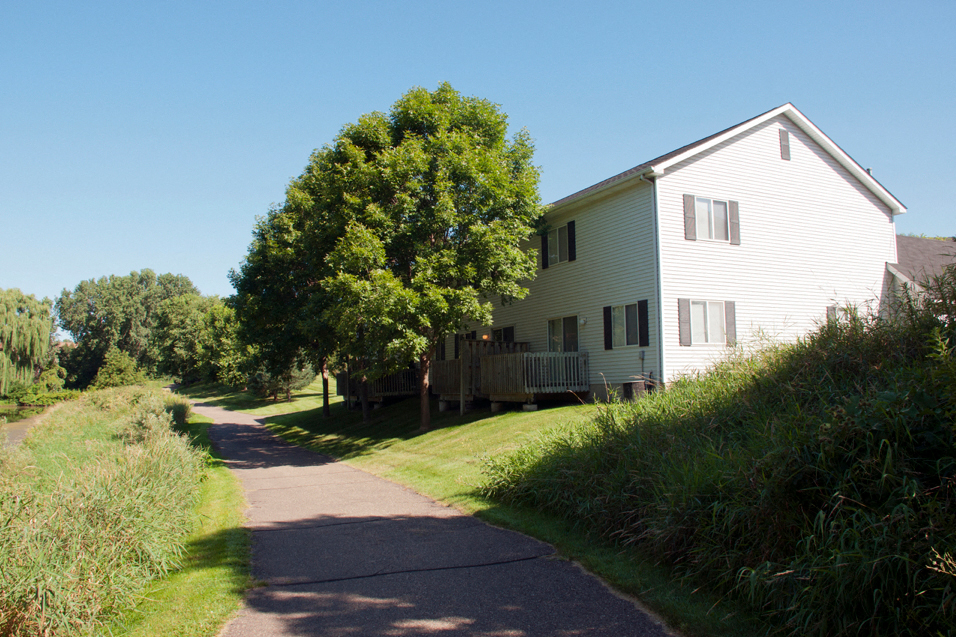 paved outdoor walking path going past a house