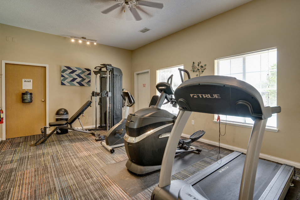 fitness room with treadmill and other equipment