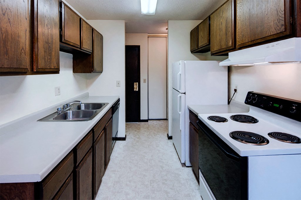 a kitchen with white appliances and wooden cabinets