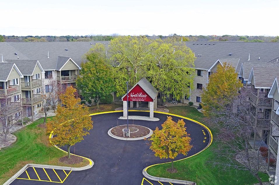 an aerial view of a parking lot with a red building