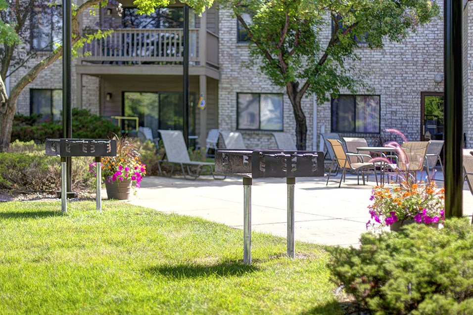 a yard with two street signs in front of a building