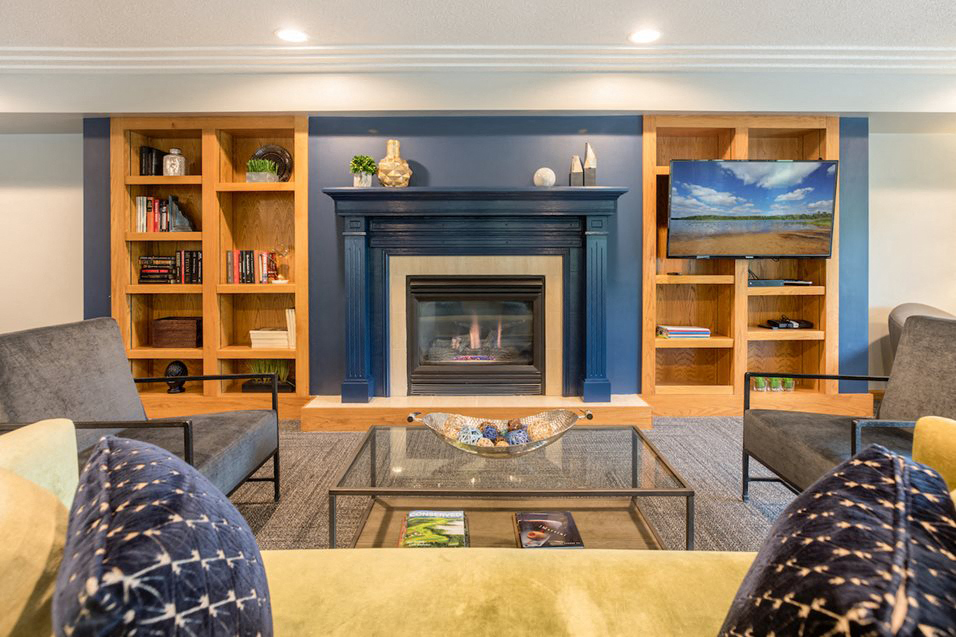 Fireplace surrounded by shelves and seating and a TV mounted to the right