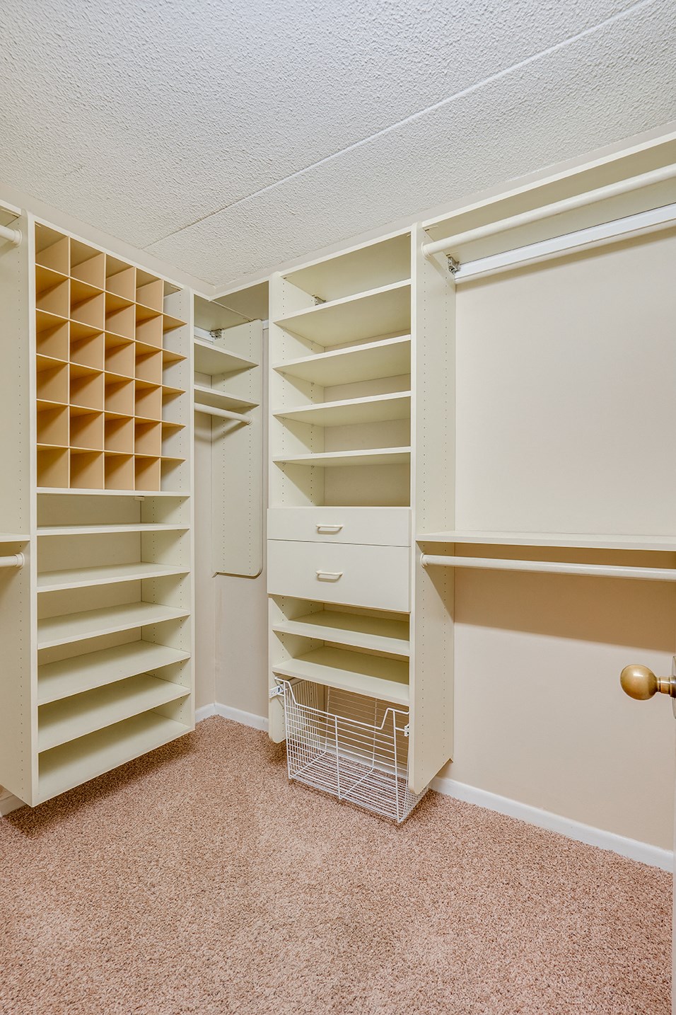 a walk in closet with shelves and a basket