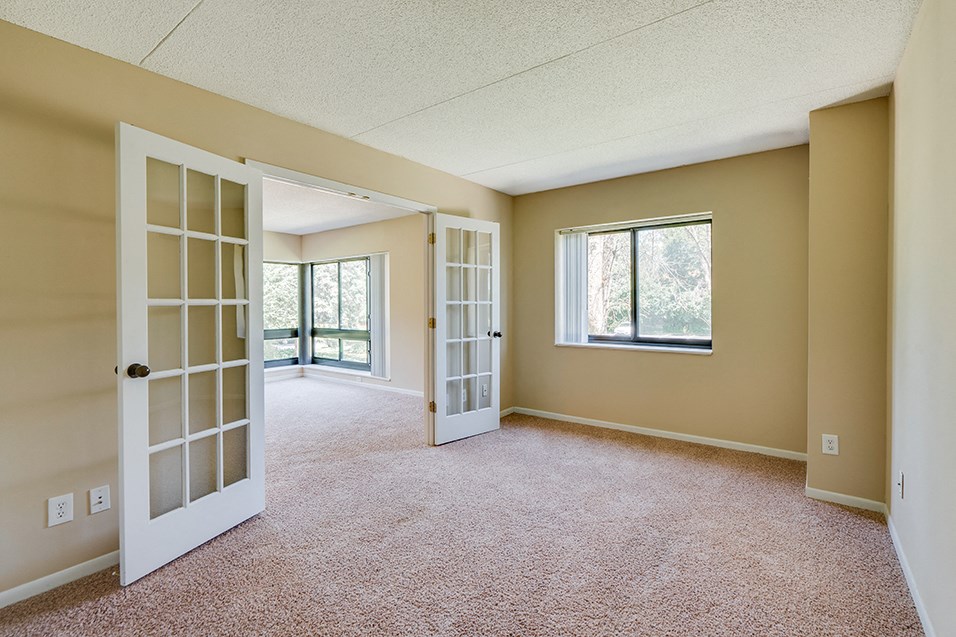 an empty living room doors and a window