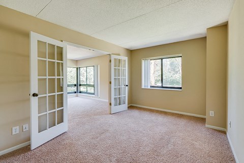 an empty living room doors and a window