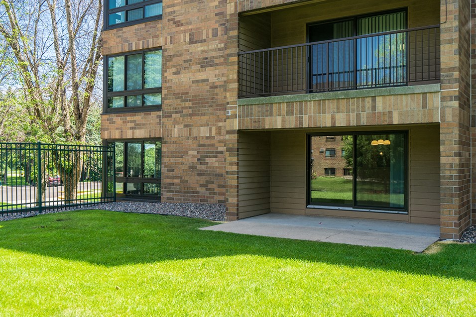 a view of the front of a building with a patio and grass