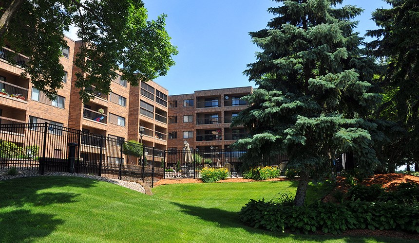 a large brick building with green grass and trees