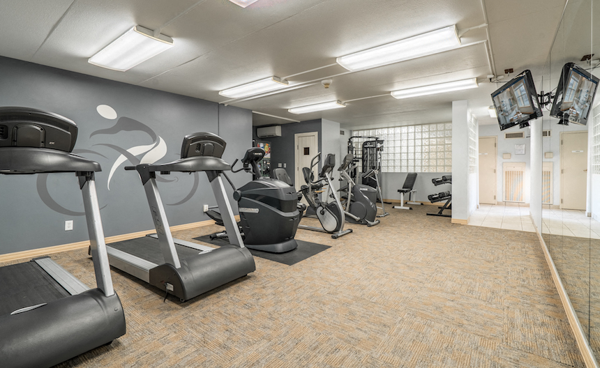 a gym with cardio equipment and weights in a building