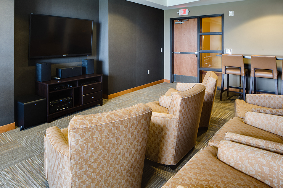 Media room with rows of chairs facing a large TV