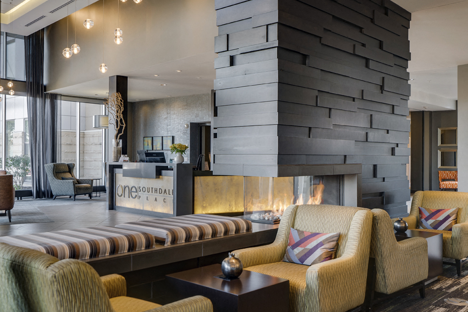 Concierge desk and lobby with chairs and a fireplace