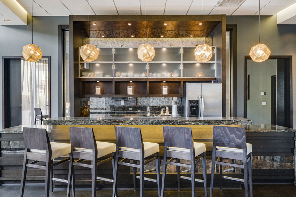 Community room with bar seating in front of long community kitchen island