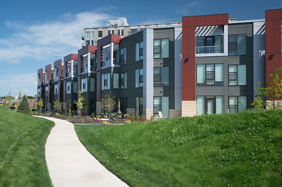 Outside of apartment building with a paved trail running alongside it