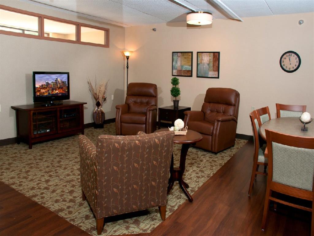 A living room with a brown leather chair and a wooden table.