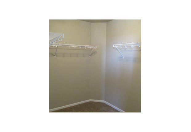 a empty closet with two shelves and two racks