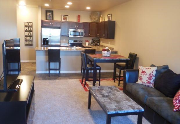 a living room with a kitchen and a table