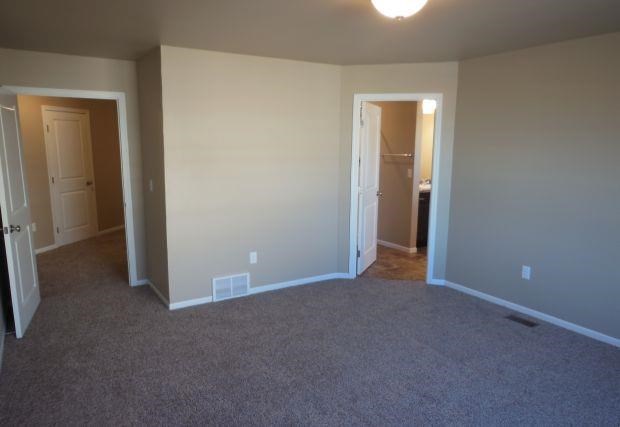 an empty living room with a door to a bathroom