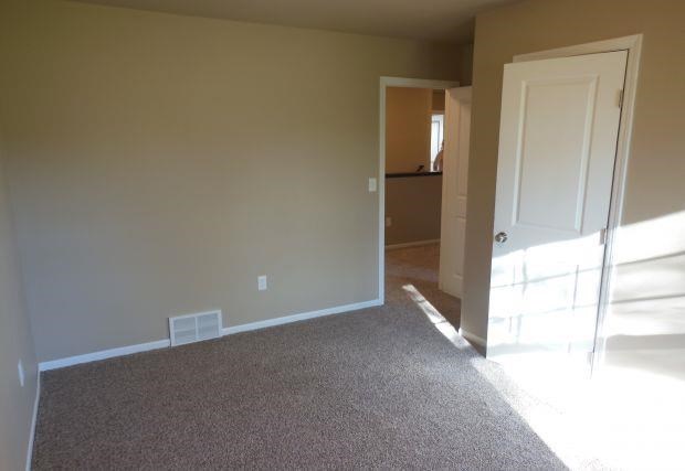 an empty room with a door and a carpeted floor