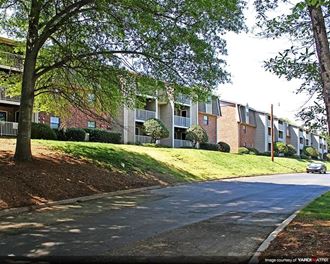 a street view of an apartment complex with a car parked in front
