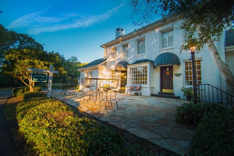 the front of a house with a stone patio and a porch