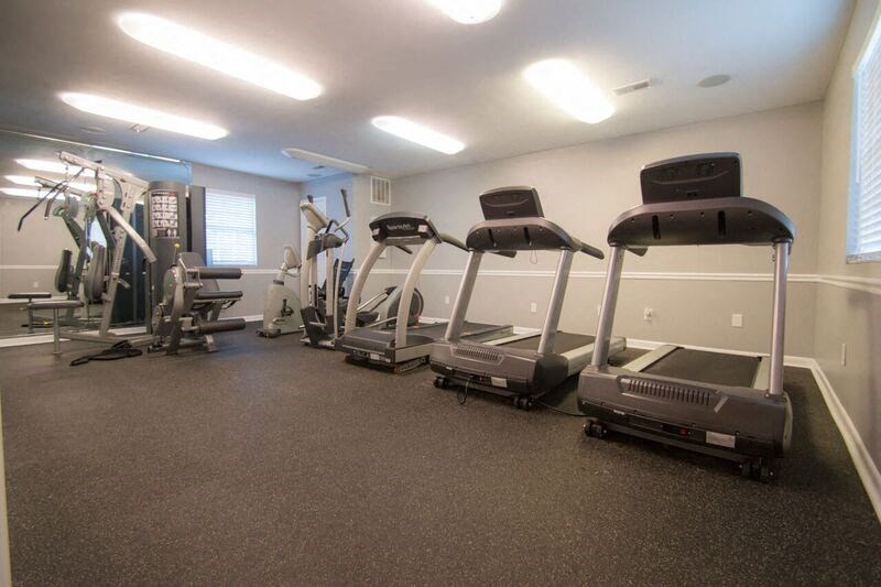 a gym with cardio equipment and weights on the floor