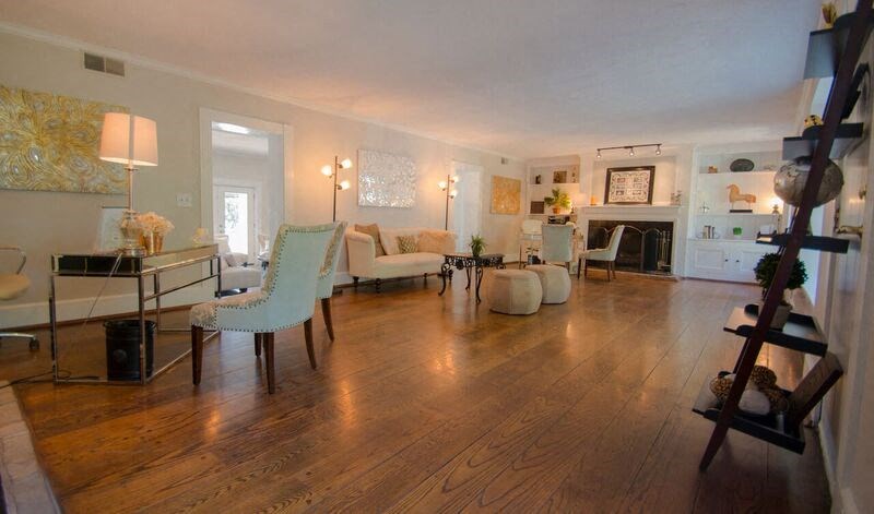 a living room with white furniture and a wooden floor