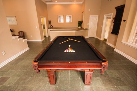 a billiards table in the center of a room in a house