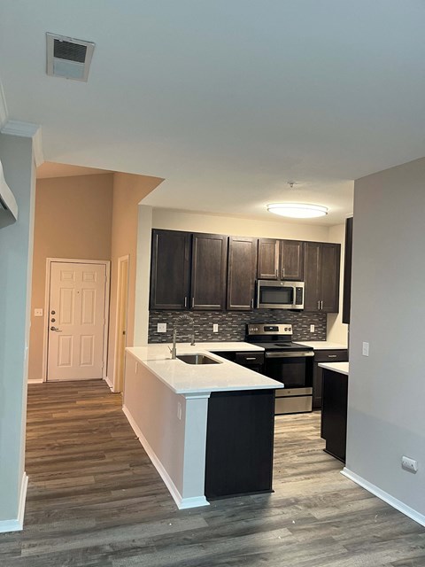 a kitchen with black cabinets and a white counter top
