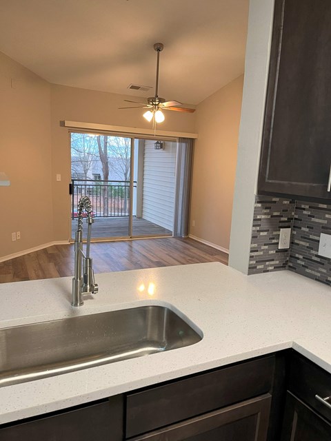 a kitchen with a sink and a view of a living room