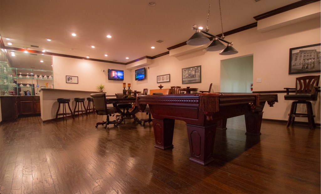 a large pool table in a room with a bar and a television